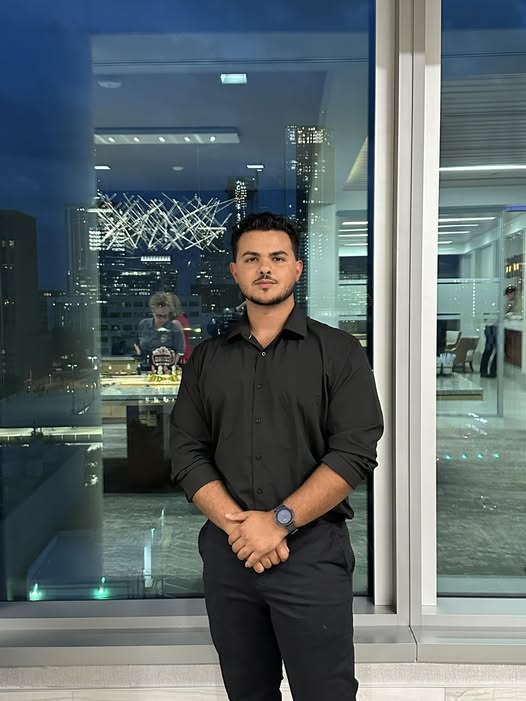 Luis, co-owner of Lovable Movers, standing in a black shirt with the Austin skyline behind him