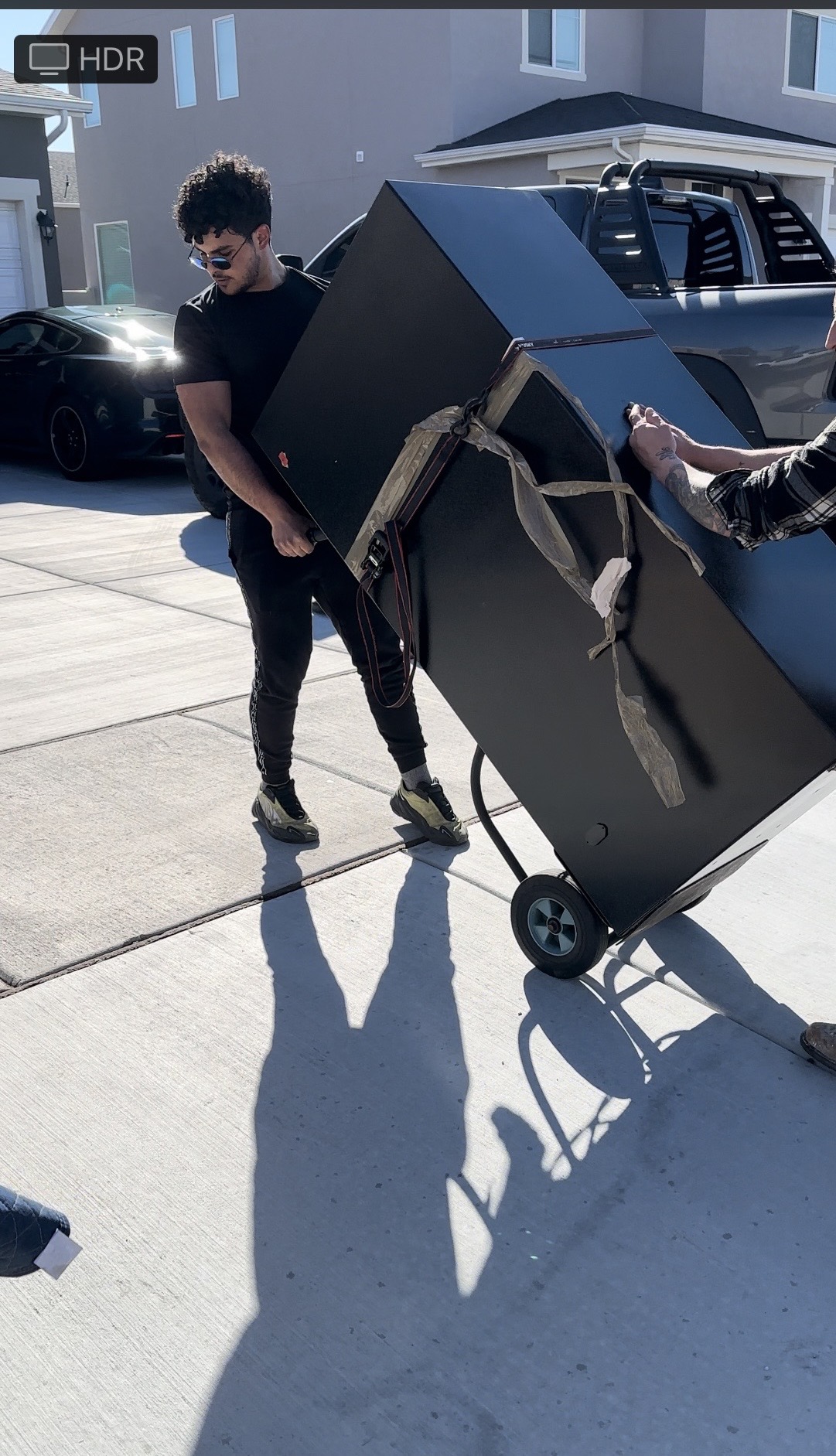 Lovable Movers crew member using a hand truck to carefully wheel a large safe out of an Austin home
